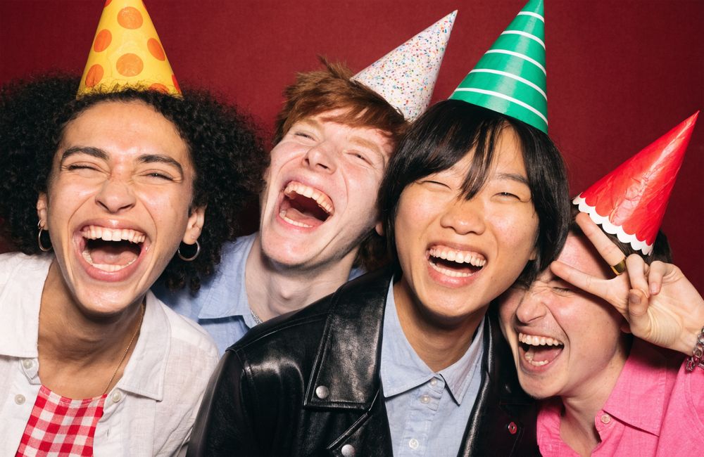 Vier Kolleginnen und Kollegen mit Partyhüten